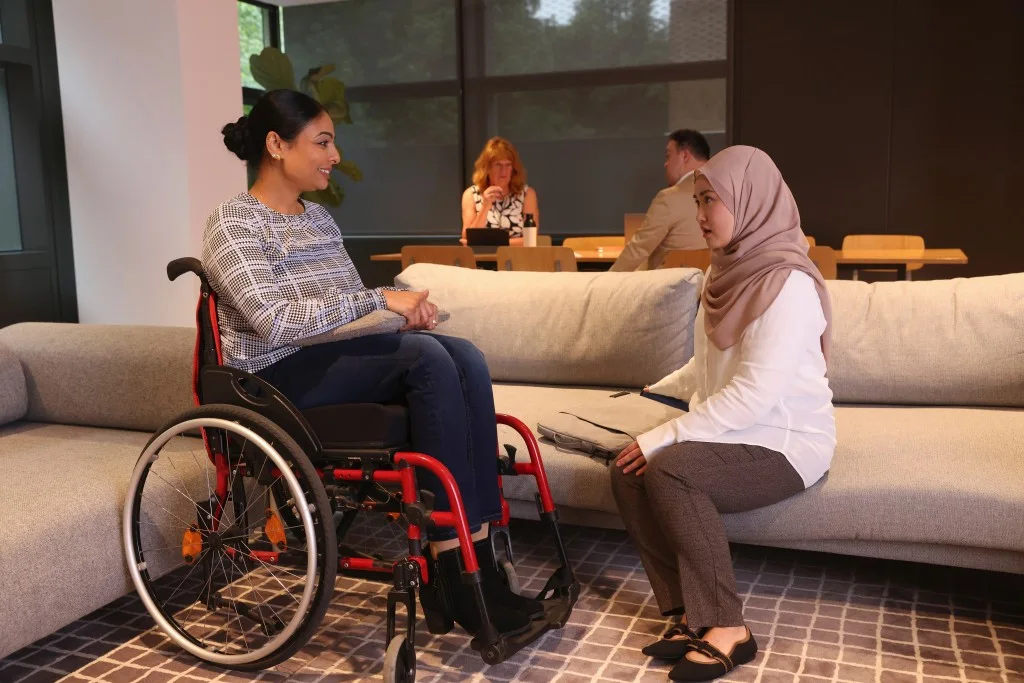 Support worker talking with NDIS participant in wheelchair