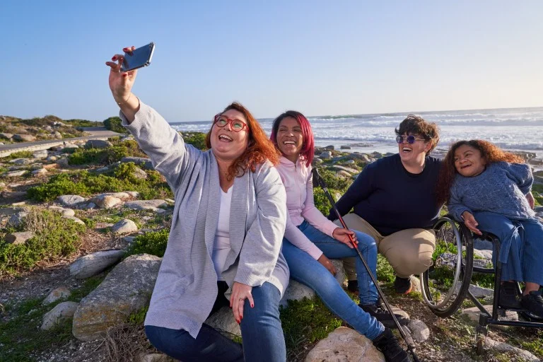 Group of diverse friends on a walk near the beach taking a photo