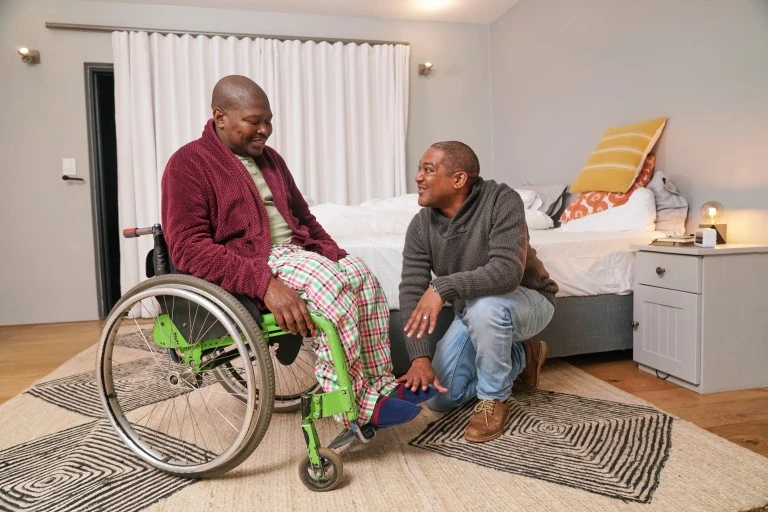 Support worker helping disabled man in wheelchair